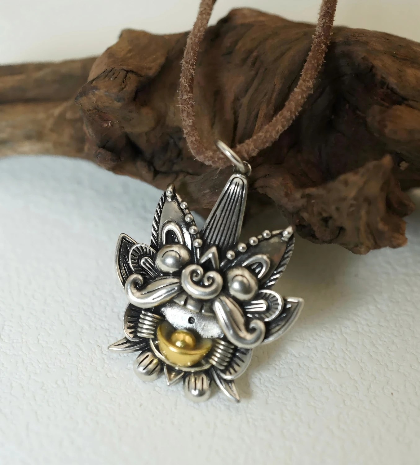 Shouxin silver pendant with a golden citrine held in its mouth, on a brown suede cord